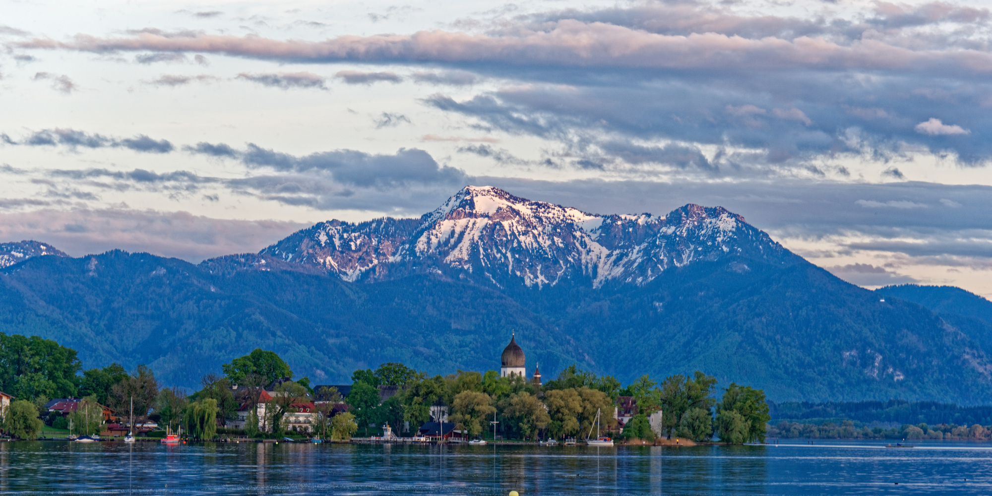 Entdecke den Chiemsee Lichtstimmung am Chiemsee mit Blick zur Fraueninsel im Hintergrund die Alpen
