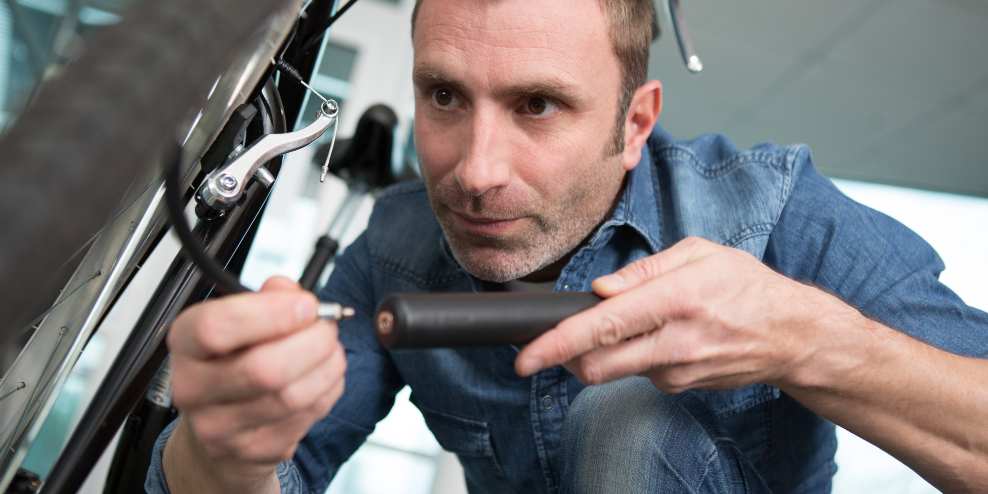 Beispielbild - Mini-Fahrradpumpe Mann pumpt einen Fahrradreifen mit einer Fahrradpumpe auf