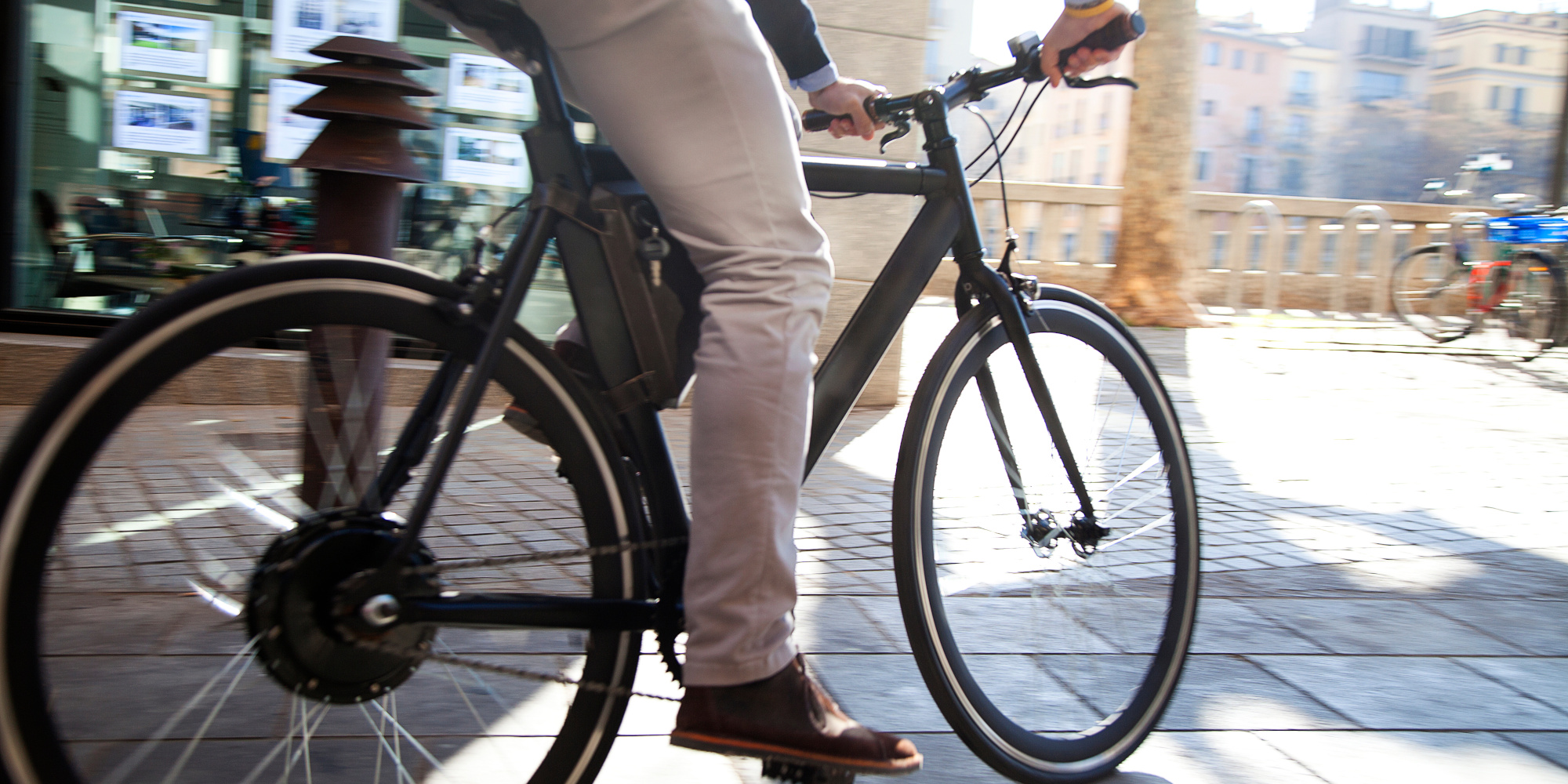 E-Bike vs. Fahrrad: Ist ein Pedelec ideal für dich, oder das klassische Rad? Mann fährt auf einem E-Bike durch die Stadt