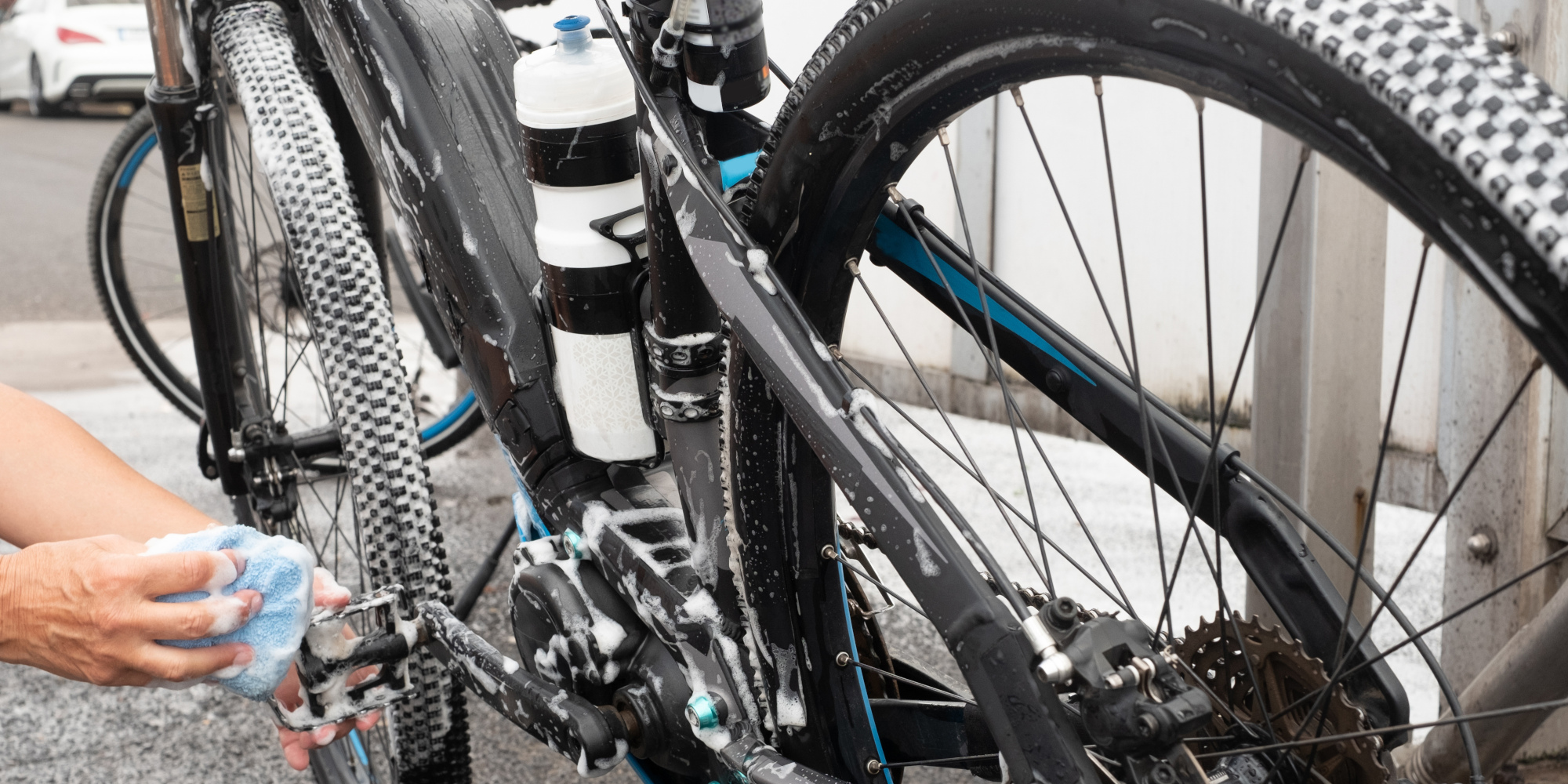 Ein Fahrrad wird mit einem Schwamm gereinigt, während es auf einem Ständer steht.