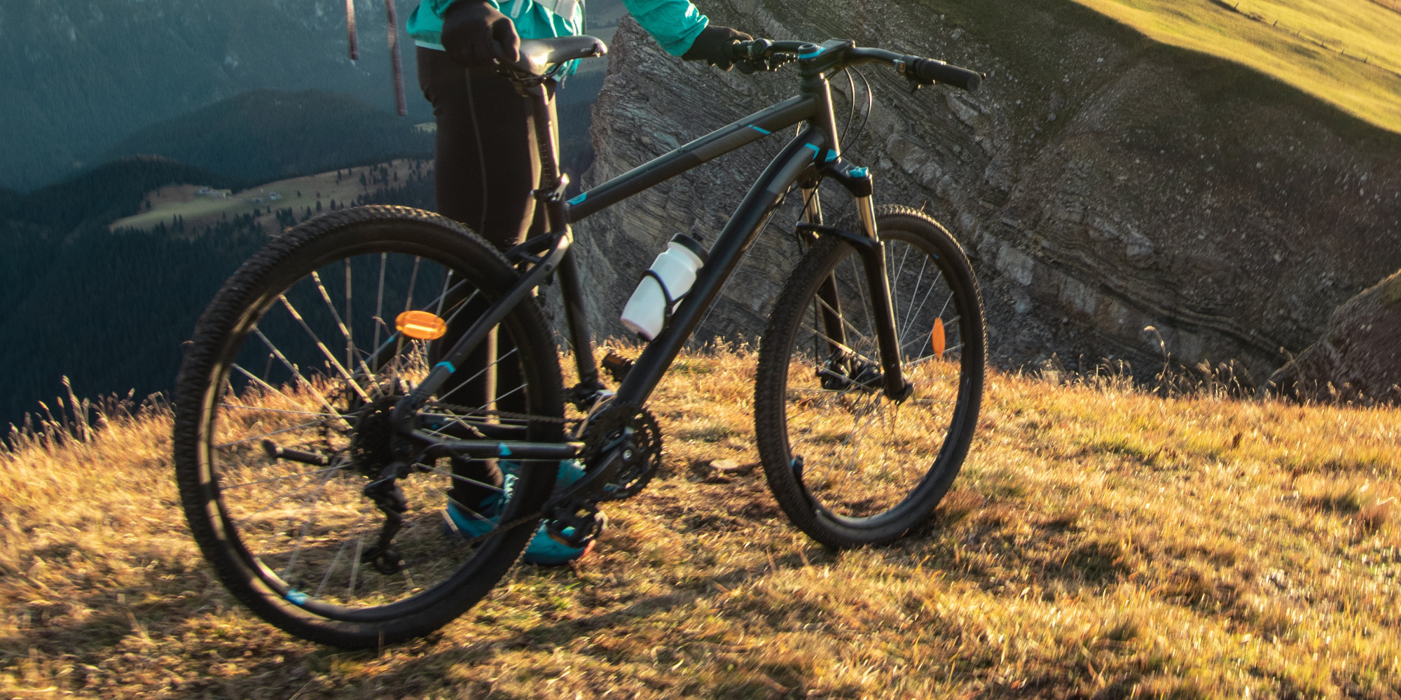 Mann hält ein Mountainbike auf einem Berg