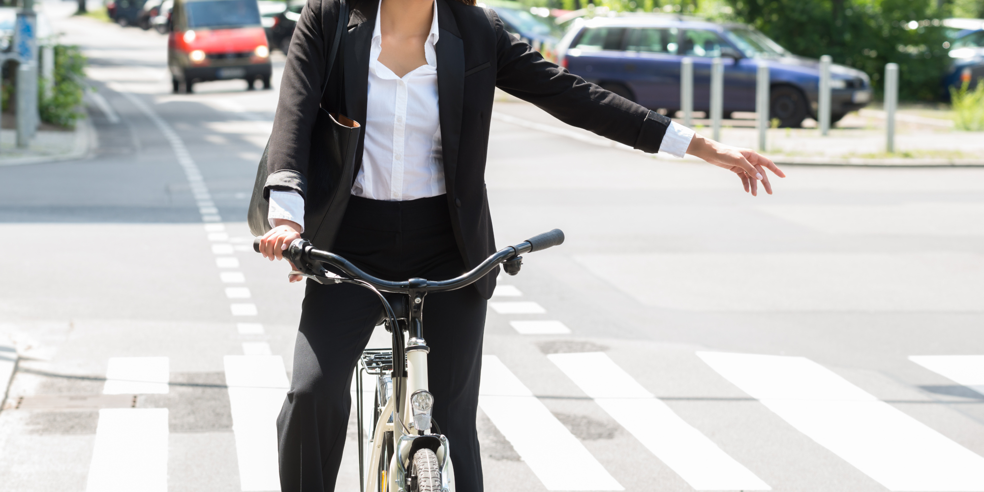 Junge Frau auf dem Fahrrad streckt den Arm aus, um das Abbiegen anzuzeigen