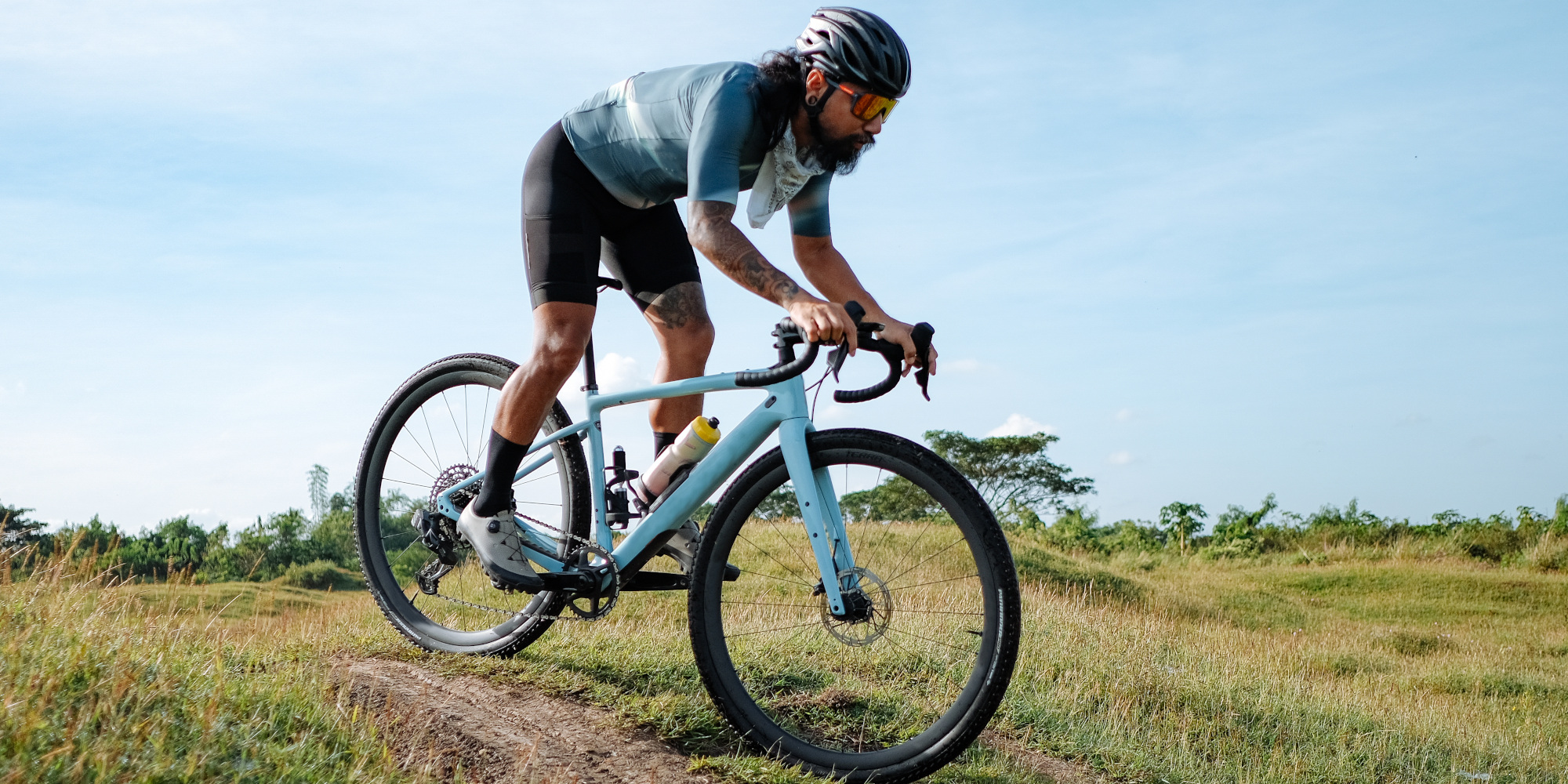 Alle Infos zum Gravelbike Radfahrer fährt mit einem Gravelbike über eine Wiese