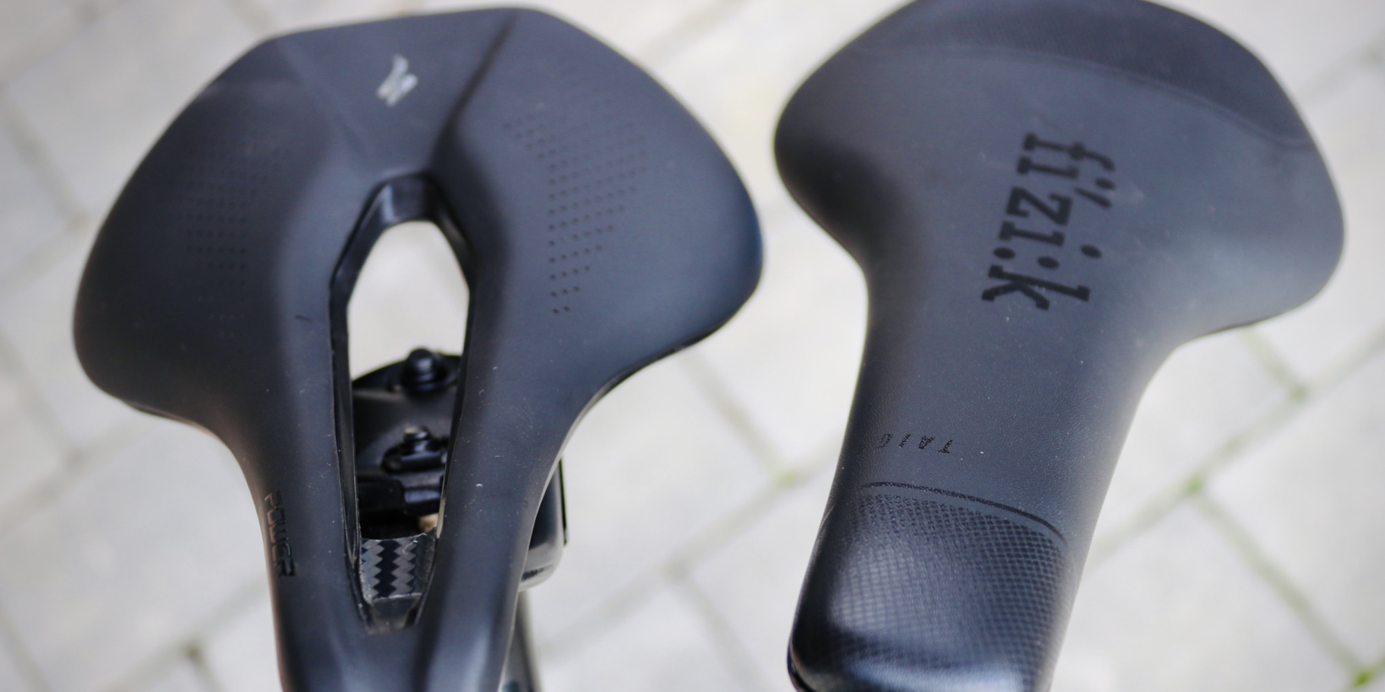 Zwei Fahrradsättel mit unterschiedlichen Designs, beide in Schwarz.