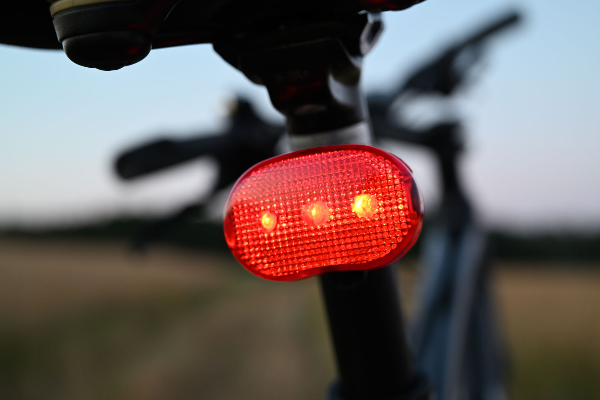 Rücklicht und Bremssysteme geben dir erhöhte Sicherheit Ein Fahrrad mit eingeschaltetem Rücklicht steht auf einer Wiese