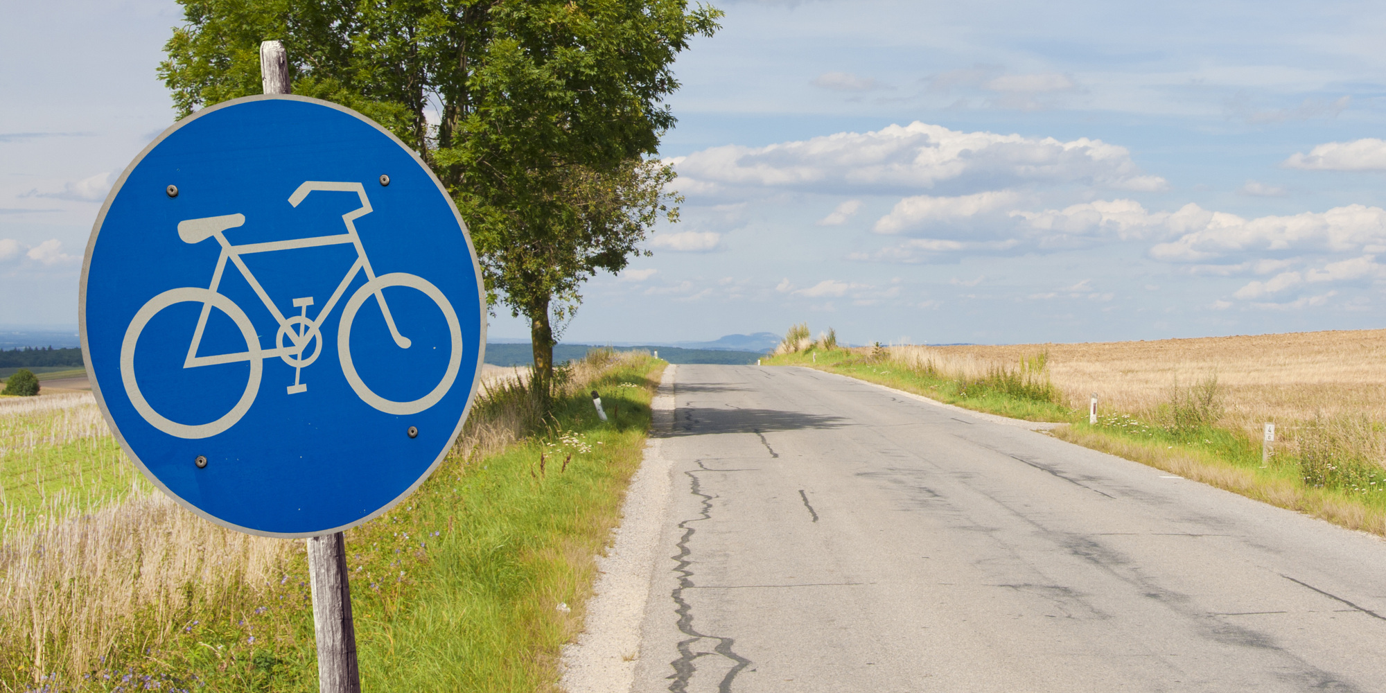 Blaues Straßenschild mit einem weißen Fahrrad 