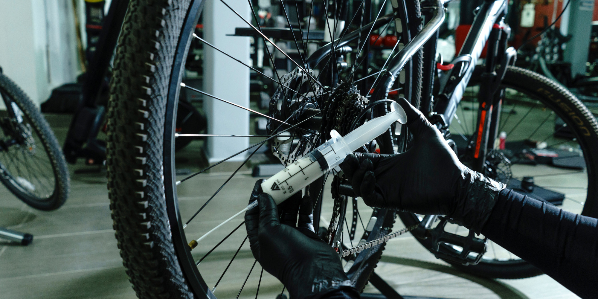 Tubeless-Reifen wird mit Dichtmilch befüllt Tubeless-Dichtmilch wird in einen Tubeless-Mountainbike-Reifen gespritzt
