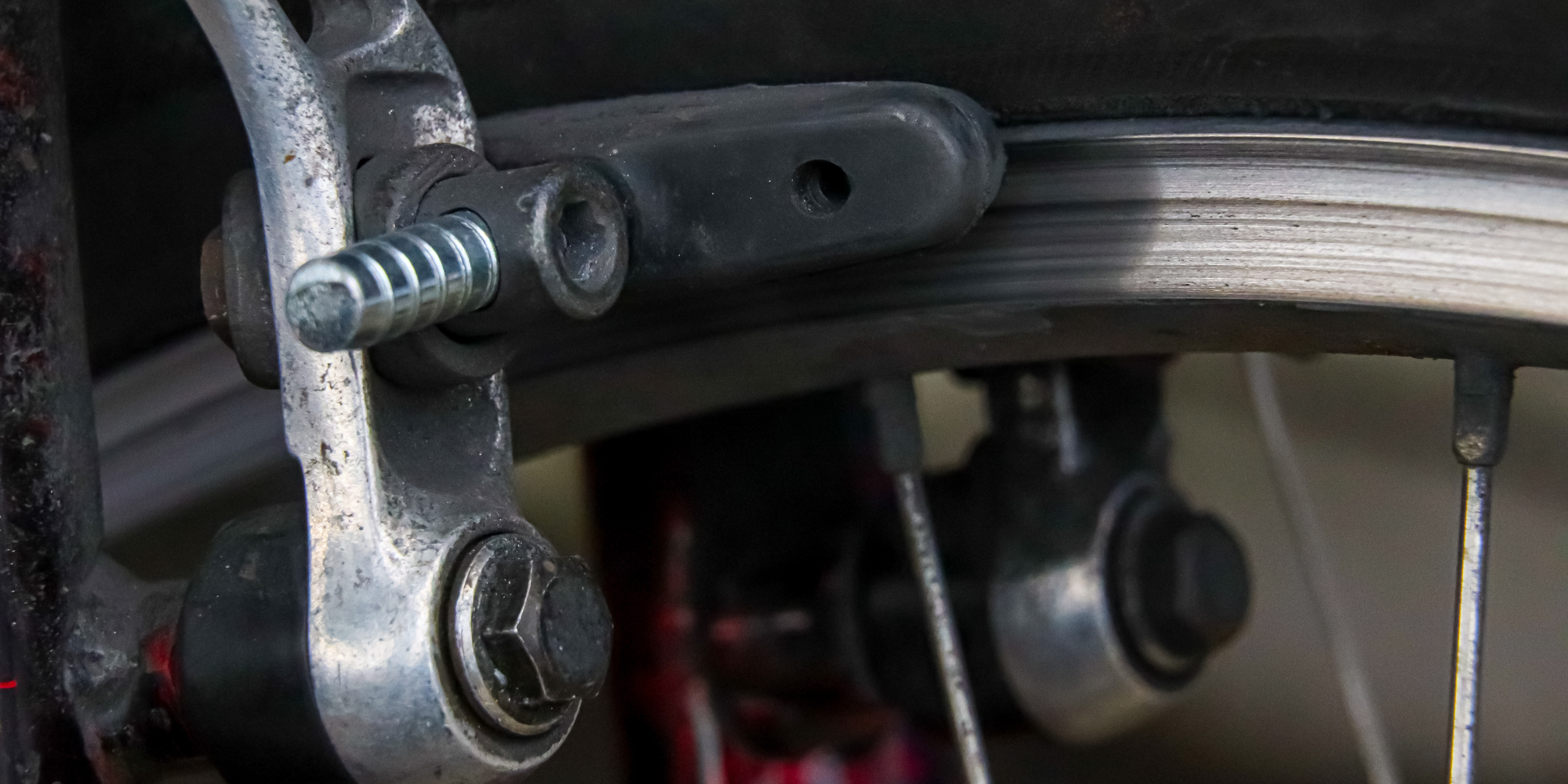 Detailaufnahme einer Fahrradbremsanlage mit Schrauben und Kabeln.