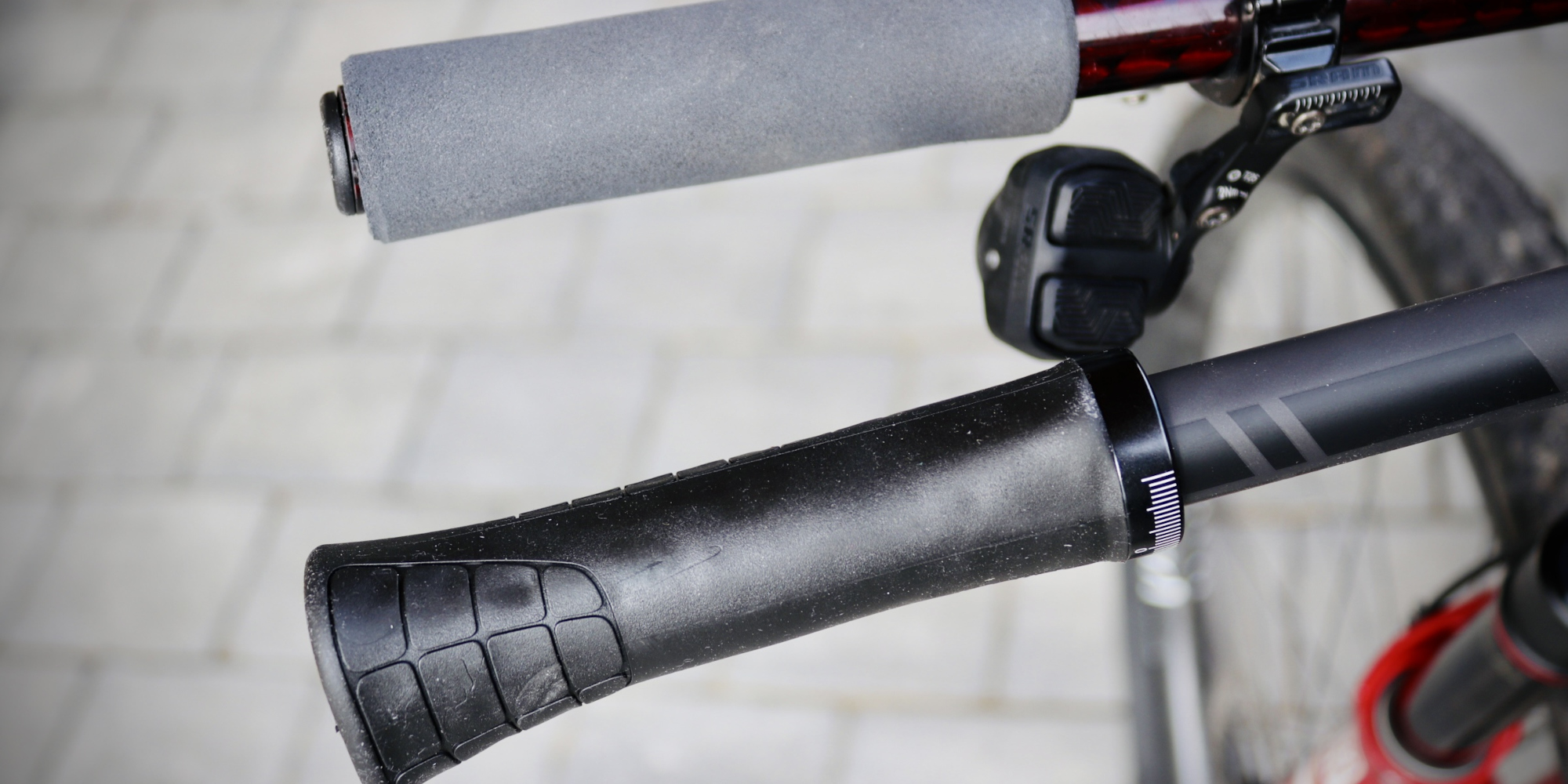 Nahaufnahme von Fahrradgriffen, ein grauer und ein schwarzer Griff.