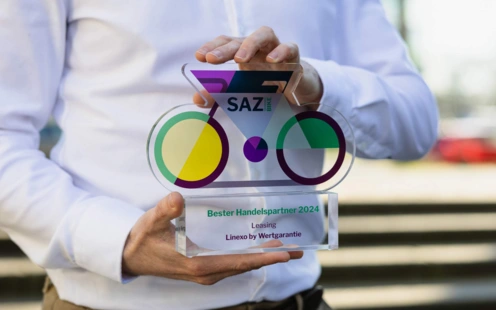 linexo Mitarbeiter hält einen Preis in der Hand mit der Auszeichnun "bester Handelspartner Leasing" von SAZ