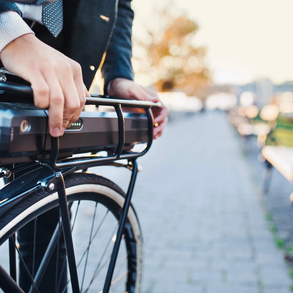 Was sie beim E-Bike fahren ohne Akku beachten sollten Nahaufnahme wie ein Mann seinen E-Bike Akku bedient