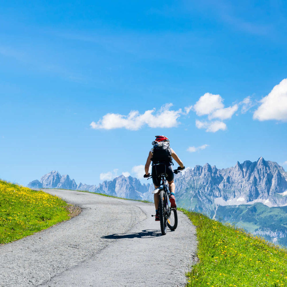 Kitzbüheler Alpen – mit dem E-Bike unterwegs Person fährt auf dem Fahrrad in den Alpen