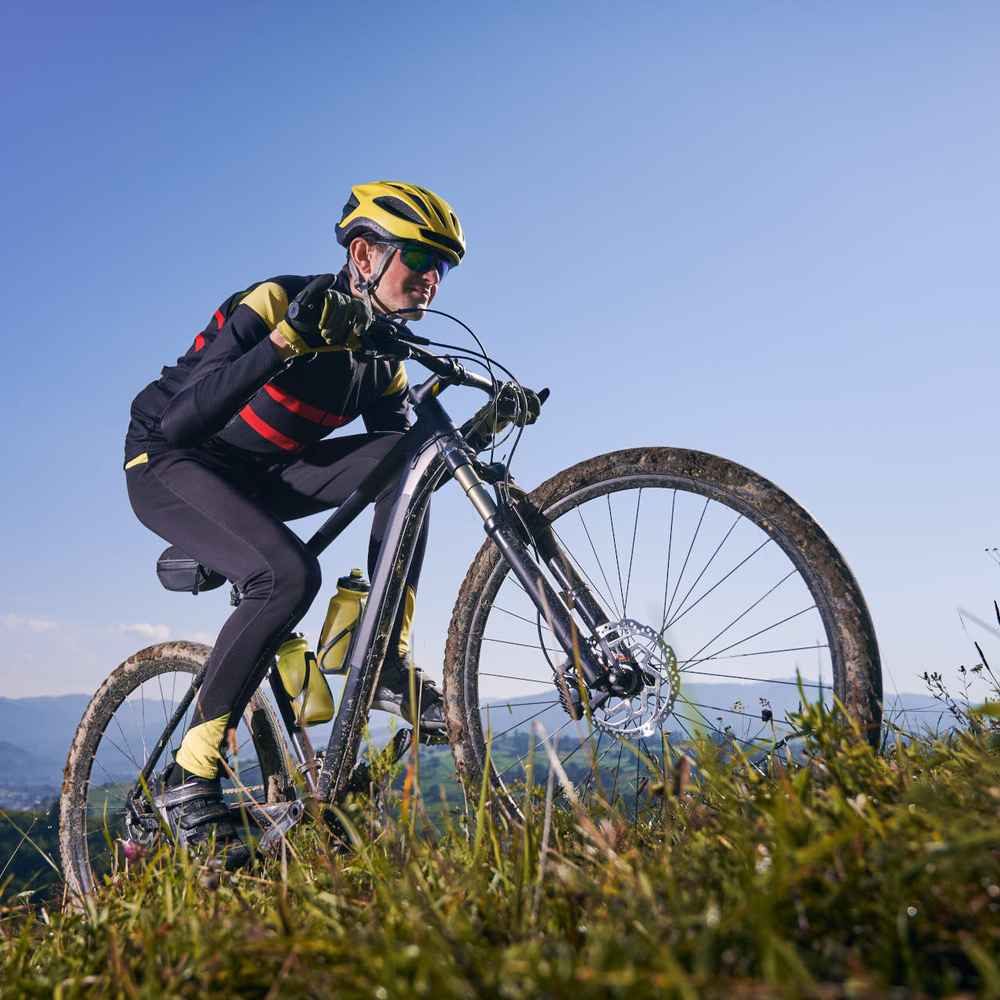 Bergauffahren kann ganz schön anstrengend sein Mann fährt bergauf mit Fahrrad