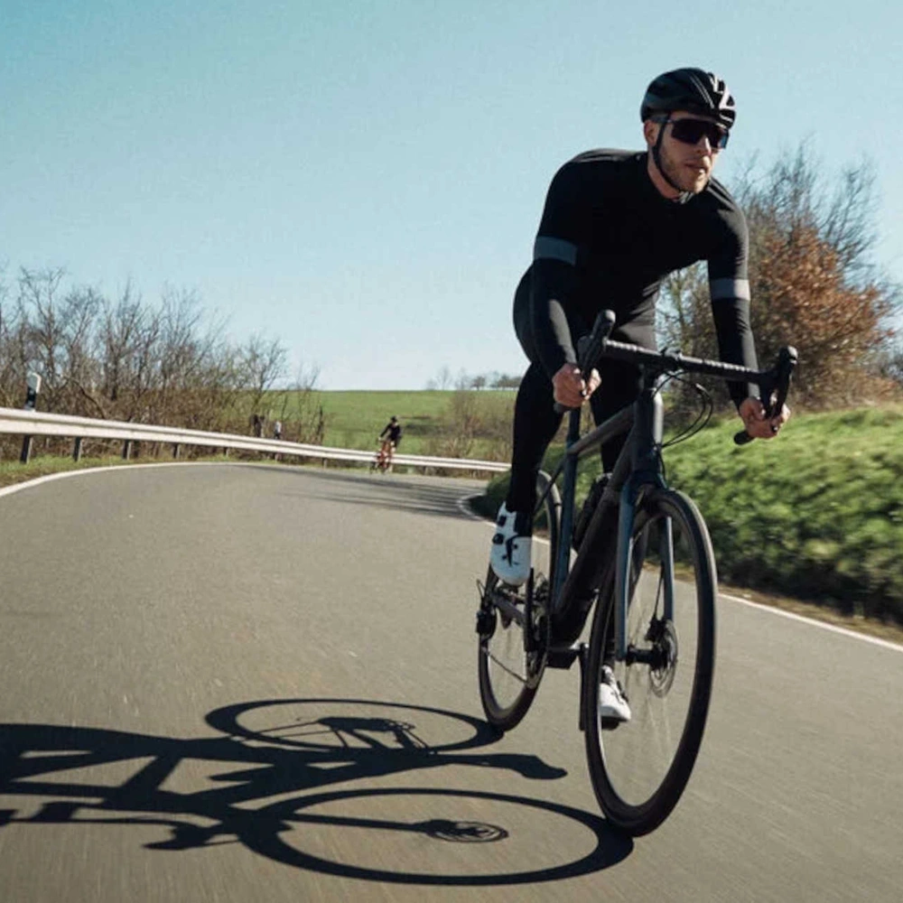 Die Fahrradmarke Canyon produziert solide Fahrräder aus allen Bereichen. Mann fährt auf Rennrad über Strasse.