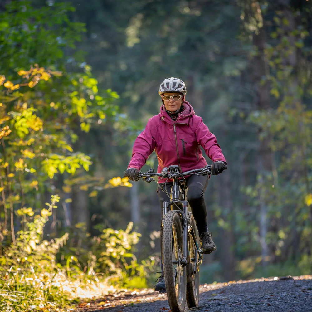 E-Bike für Damen - unsere Tipps Eine Frau fährt im Wald ihr E-Bike