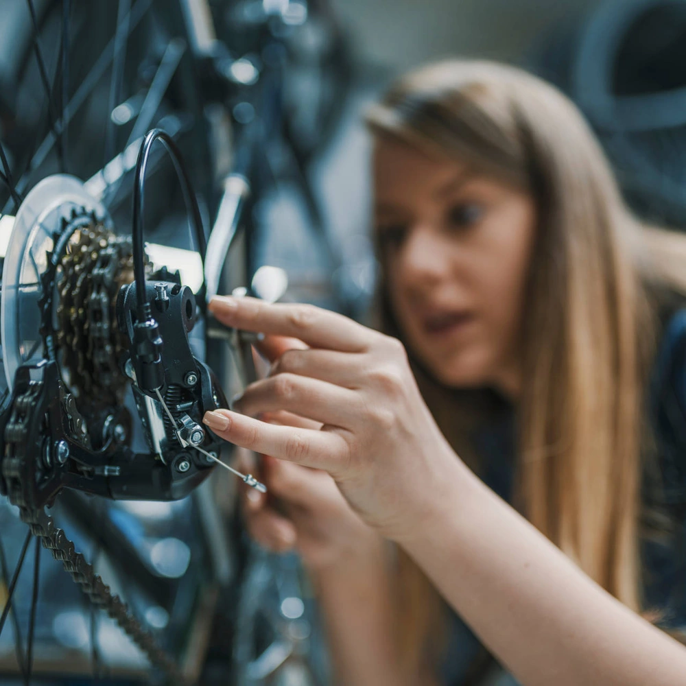 E-Bike selbst reparieren - eine gute Idee? Frau repariert ein E-Bike