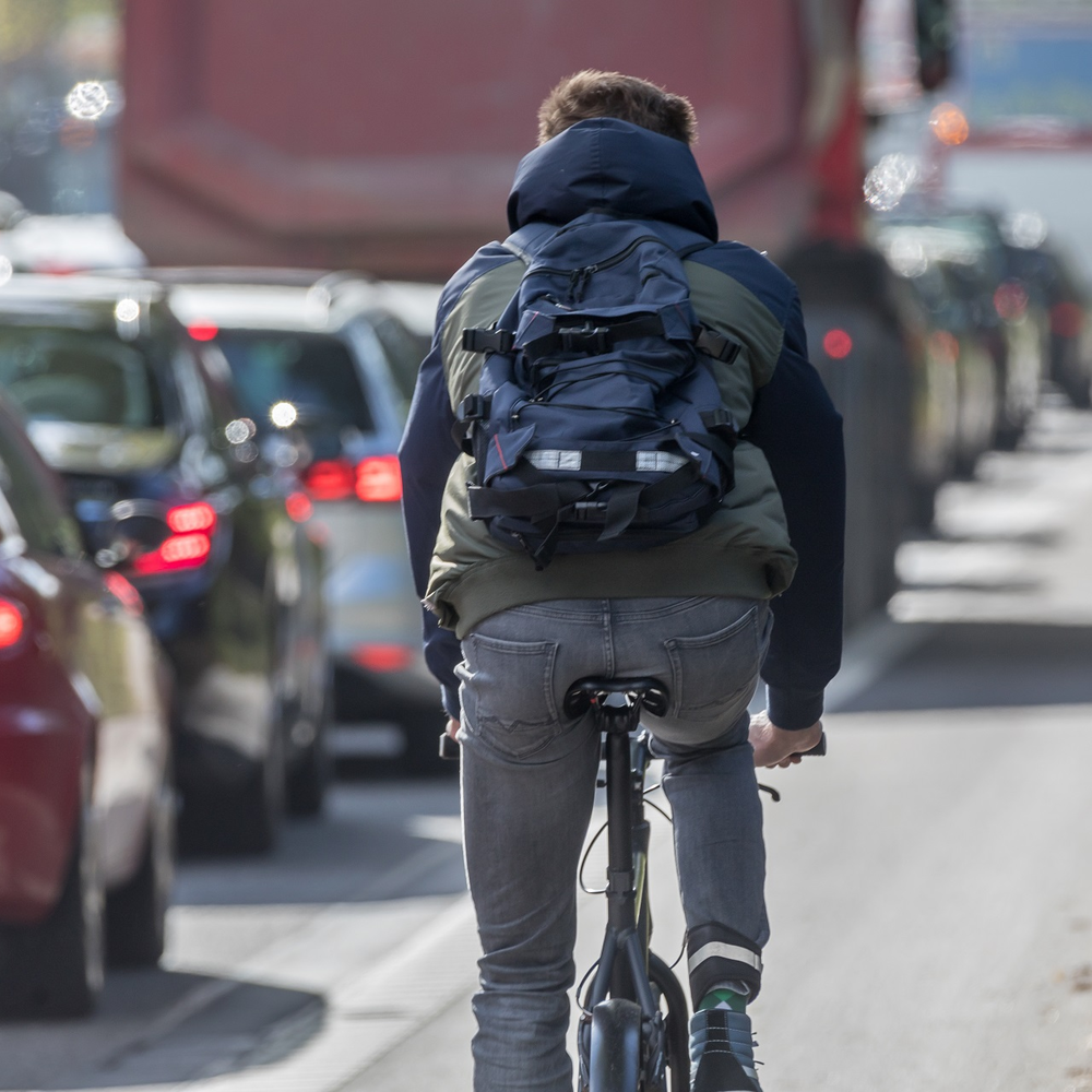 Fahrrad statt Auto: eine Alternative für Umwelt und Gesundheit Ein Radfahrer fährt am Stau vorbei.