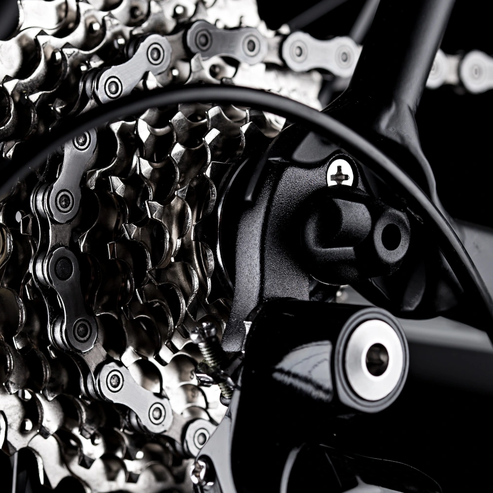 Nahaufnahme eines Fahrradkettenantriebs auf schwarzem Hintergrund.