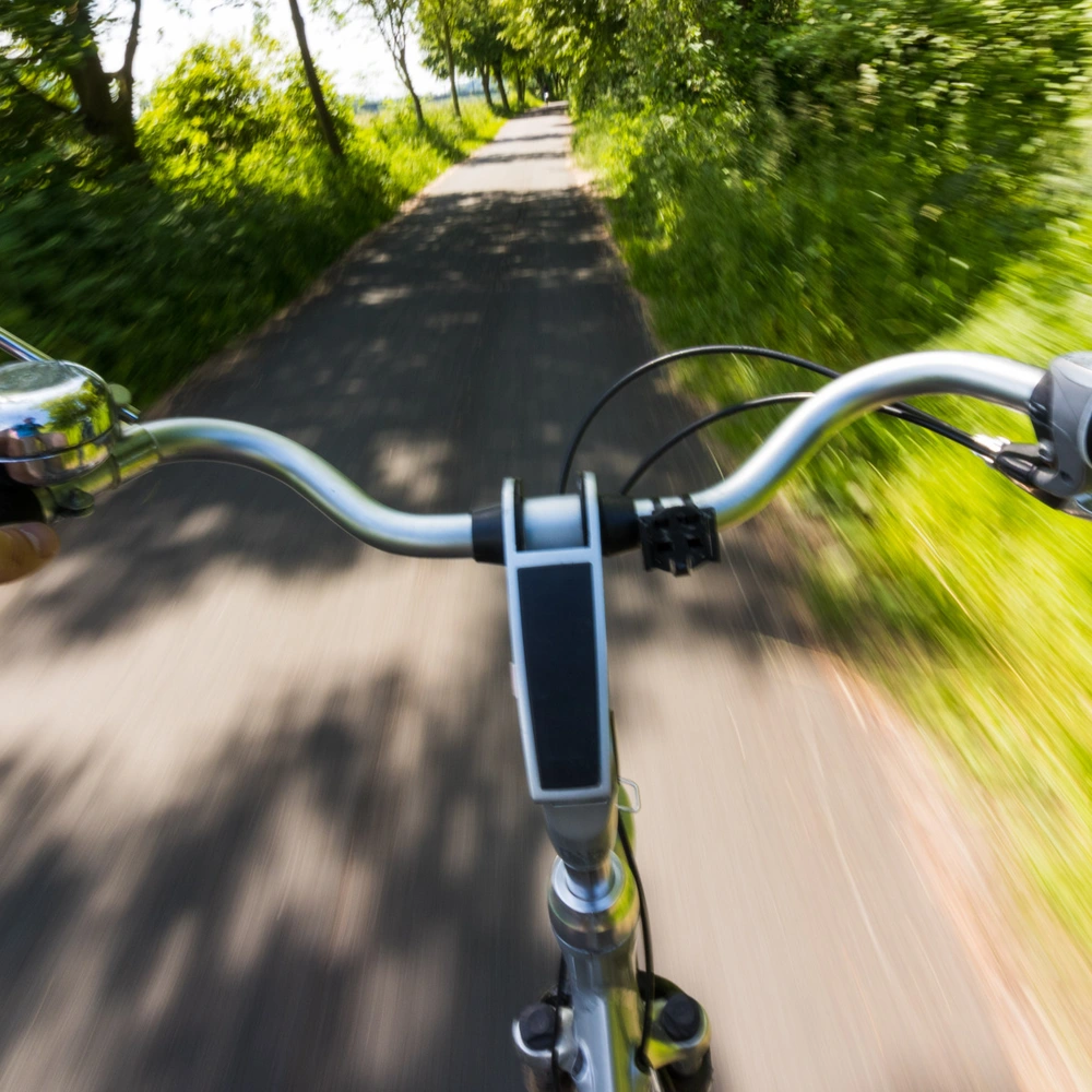 Der große Fahrradspiegel Test 2025 Radfahrer fährt mit hoher Geschwindigkeit mit einem Rad mit Fahrradspiegel