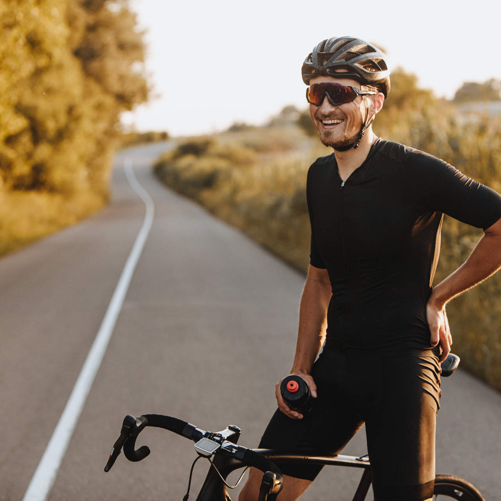 Training für Kopf und Körper mit dem Fahrrad Mann sitzt lächelnd auf Rennrad