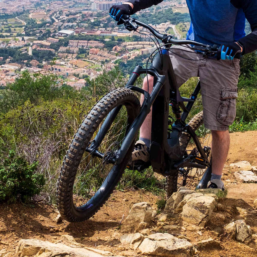 Die neuen Focus Light E-MTB Modelle in der Übersicht. Mann fährt steilen Berg mit E-MTB hoch.