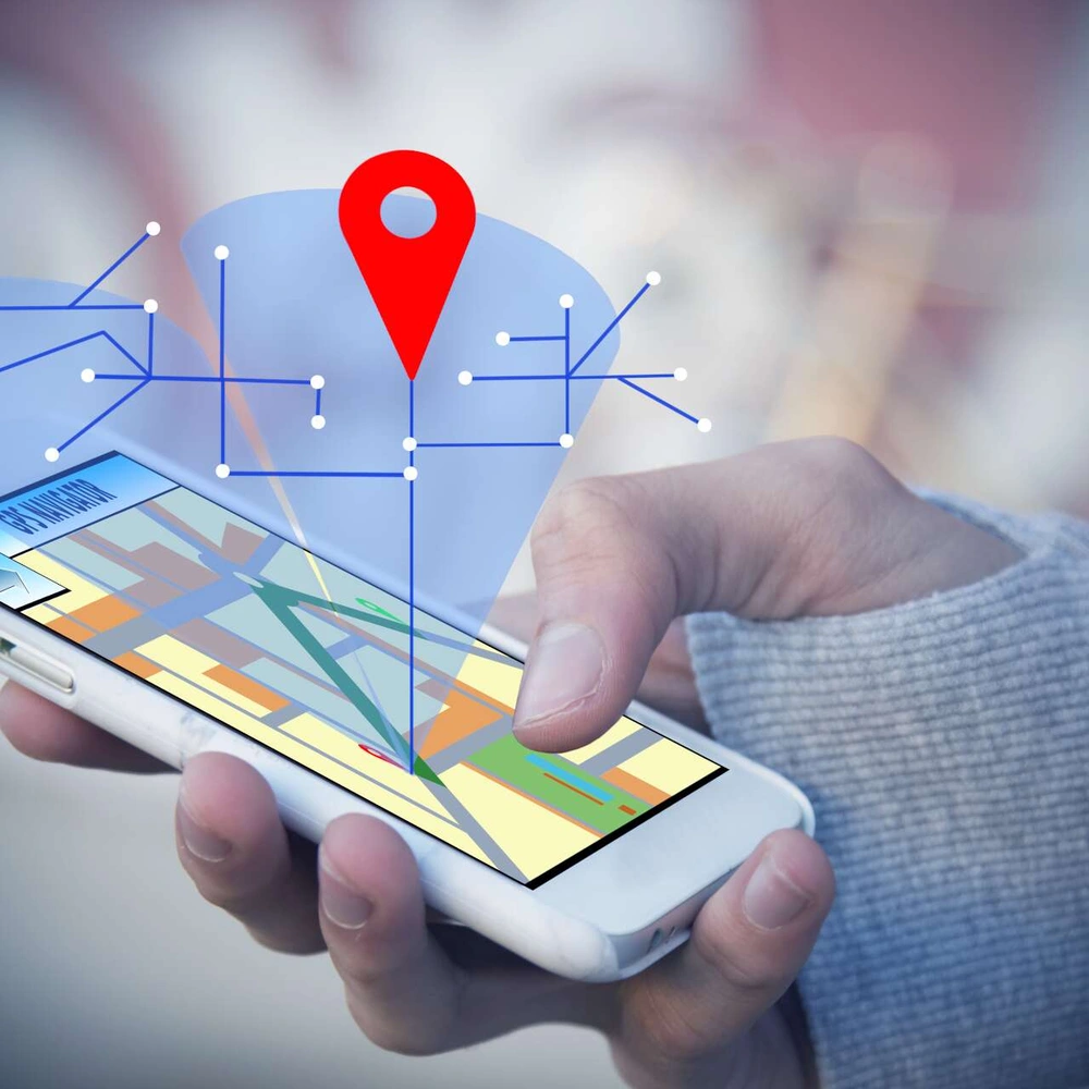 GPS-Tracker fürs Fahrrad: So hast du dein Bike im Blick Composing aus Smartphone in der Hand eines Nutzers und grafischen Standortkoordinaten