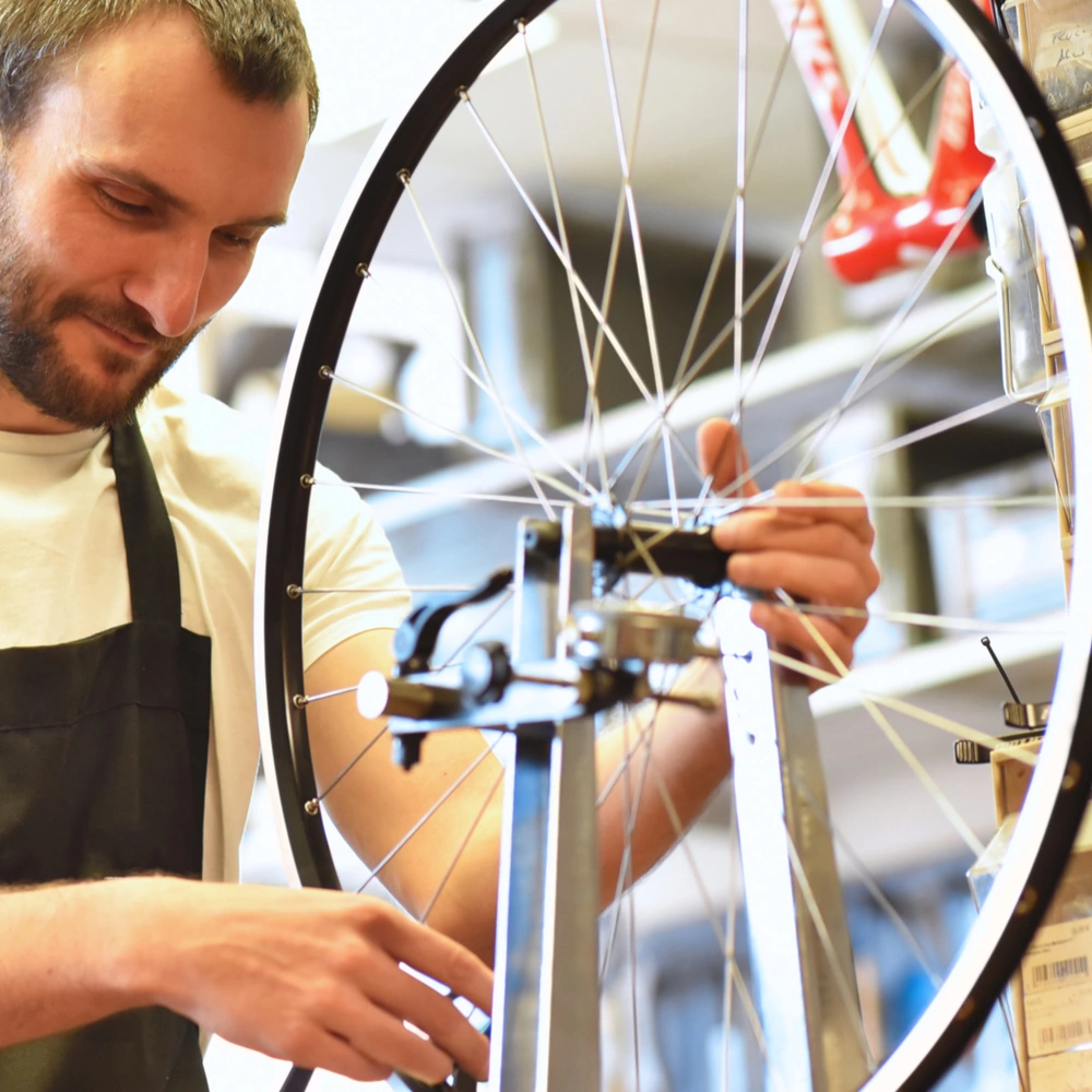 So zentrierst du dein Laufrad Mechaniker zentriert Laufrad eines Fahrrades in der Werkstatt