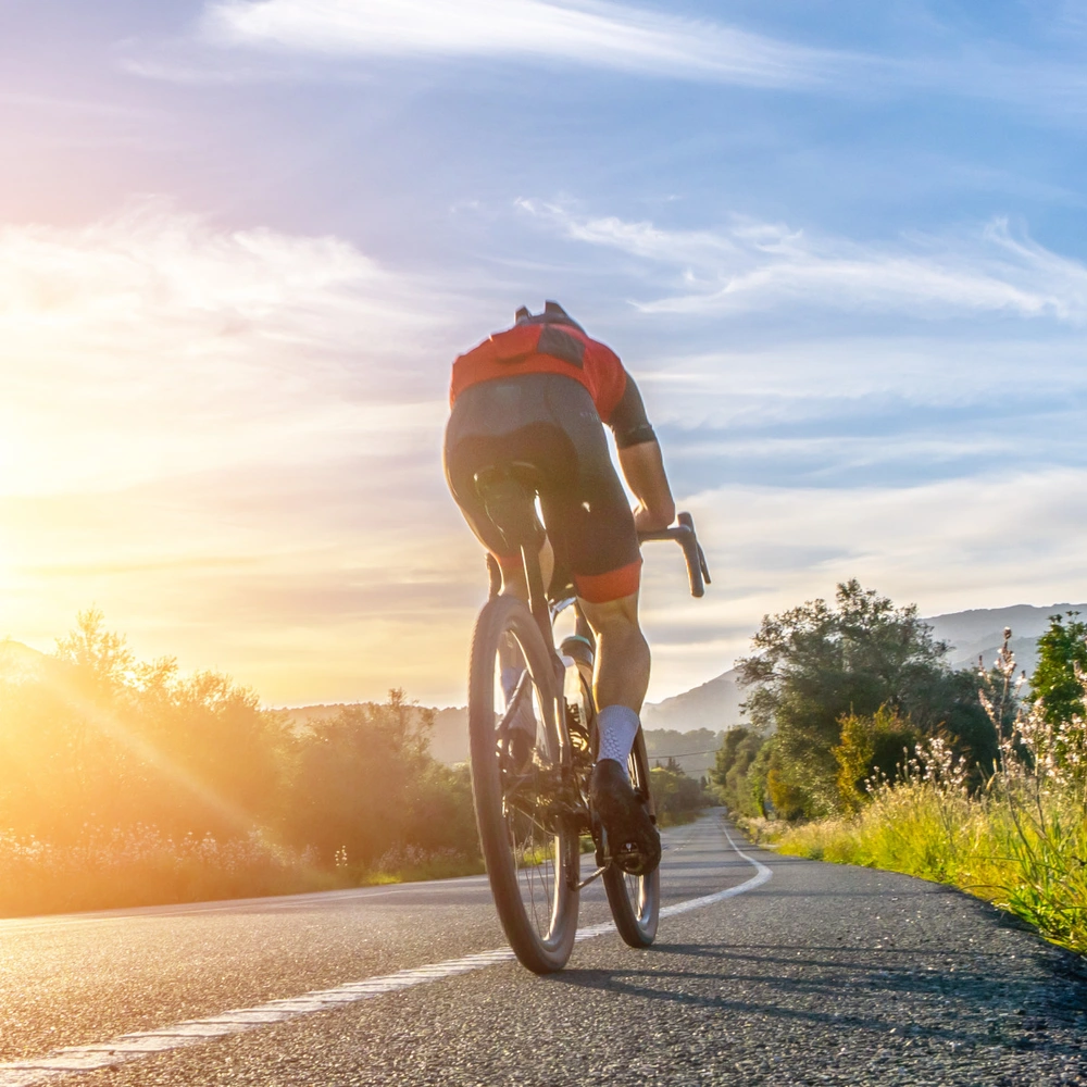 Mann fährt auf einem sportlichen Fahrrad eine Straße entlang