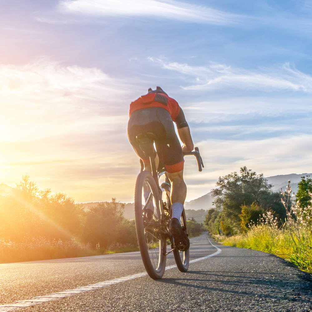 Entdecke die innovativen Lemmo Bikes Mann fährt auf einem sportlichen Fahrrad eine Straße entlang