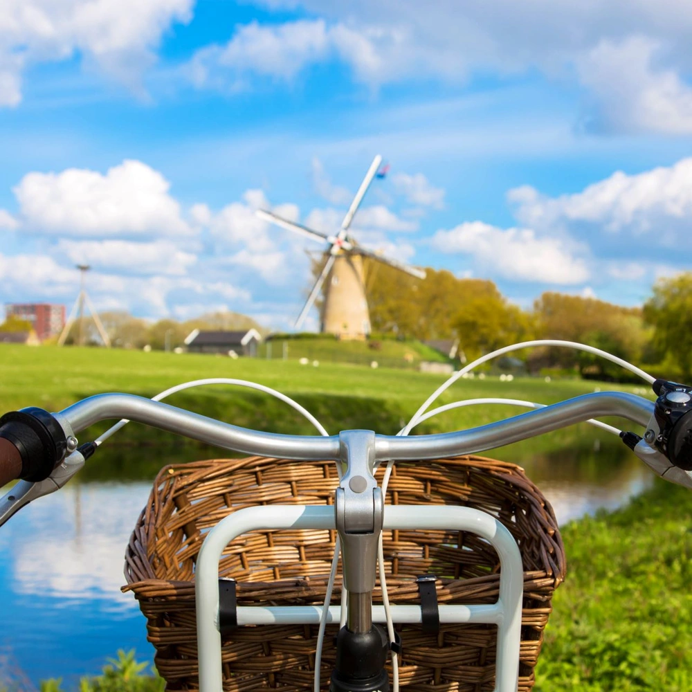 Niederlande Fahrradtour: Die Strecken musst du kennen. Fahrrad in den Niederladen mit Blick auf eine Windmühle
