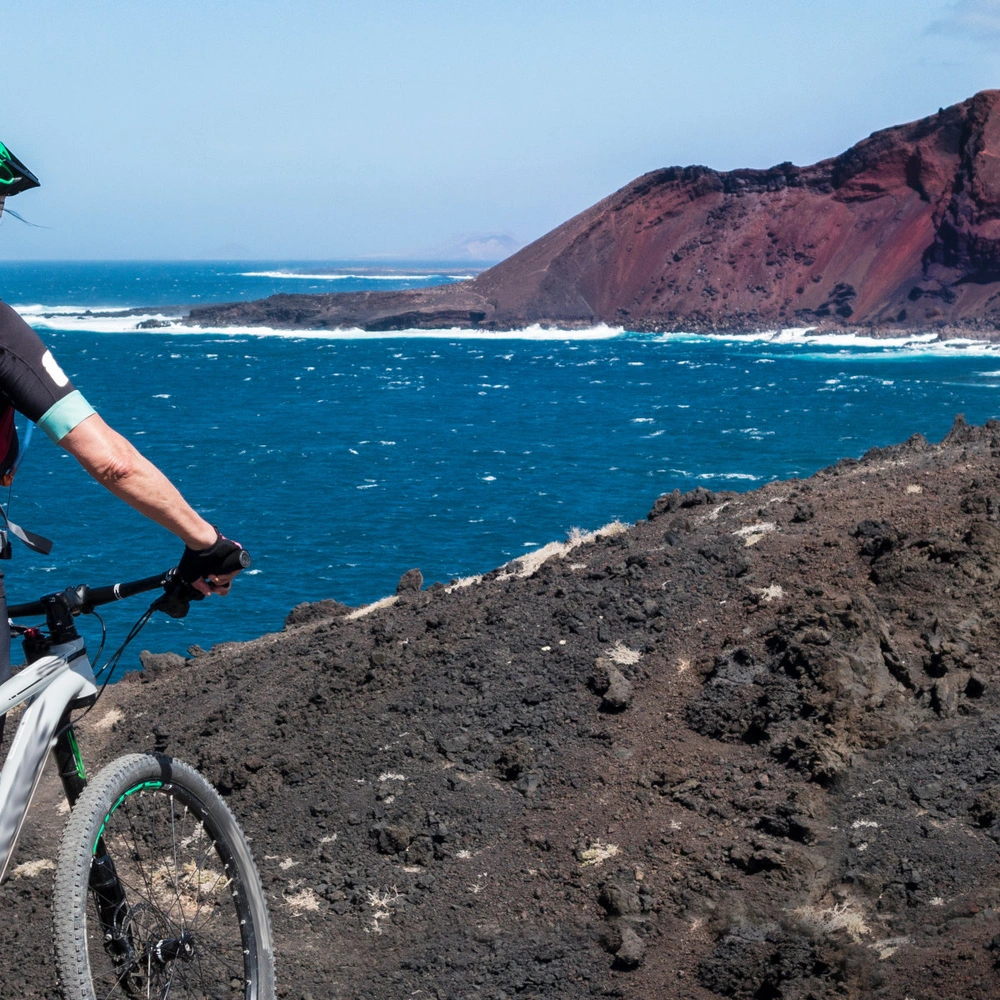 Seniorin unterwegs mit dem Mountainbike auf der Insel Lanzarote auf den Kanarische Inseln 