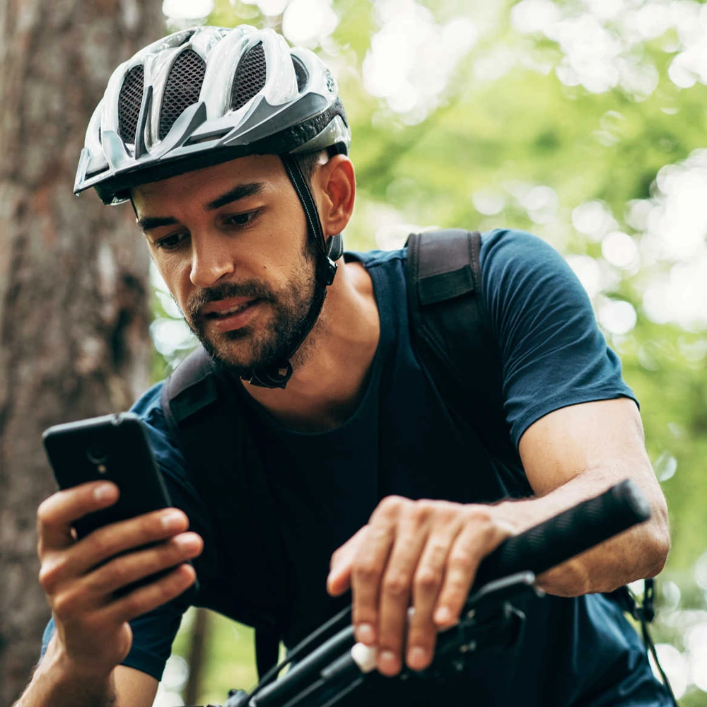 Die Strava App – auch fürs Radfahren geeignet Fahrradfahrer bedient sein Handy