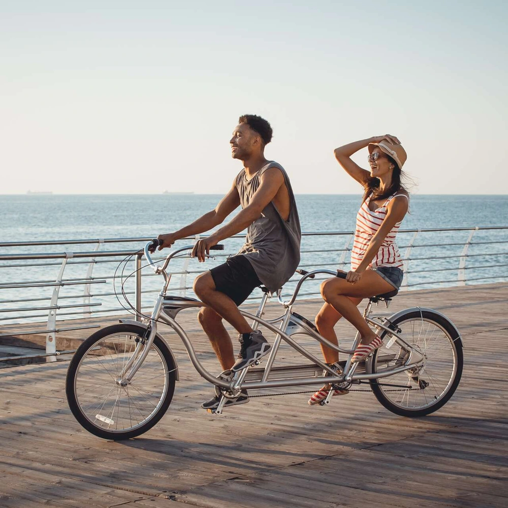 Tandemfahren: Fahrvergnügen hoch 2 Ein Paar fährt Tandem am Meer.
