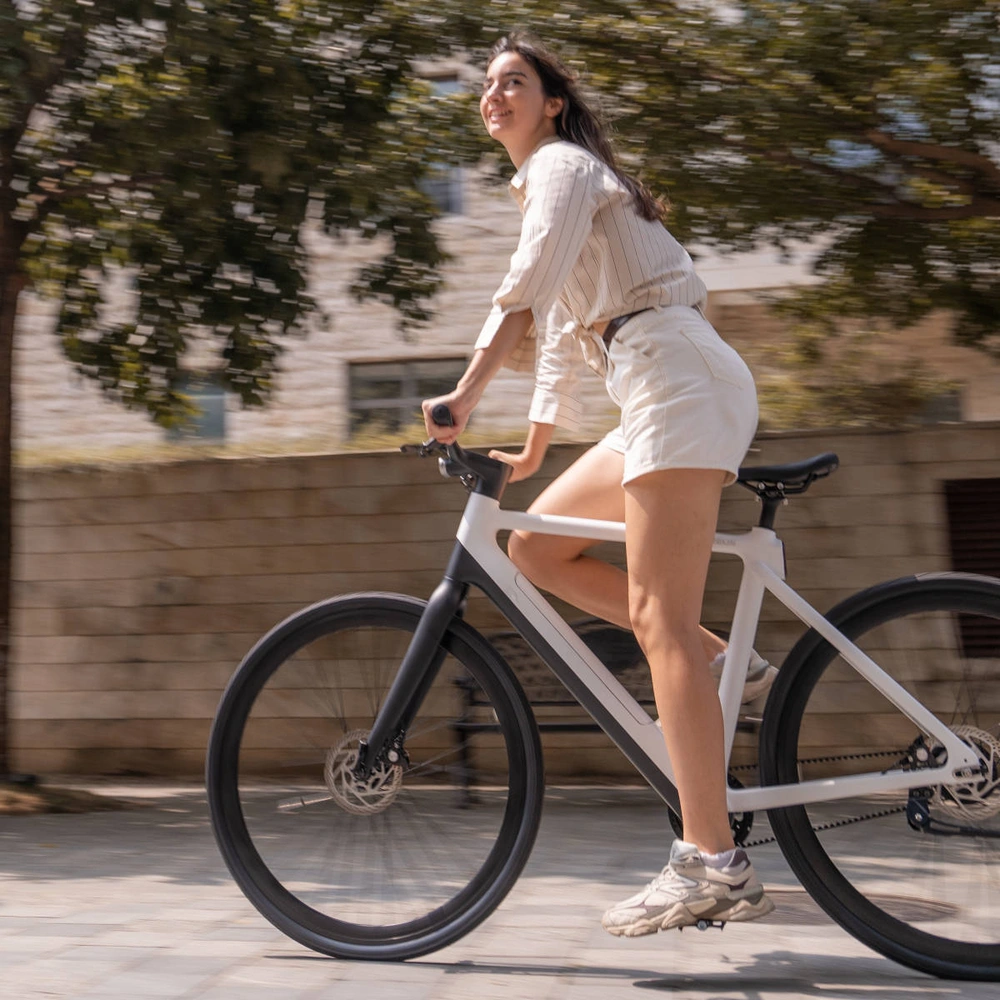 Das neue urban E-Bike von Tezeus. Frau fährt auf Tezeus C8 durch Stadt.