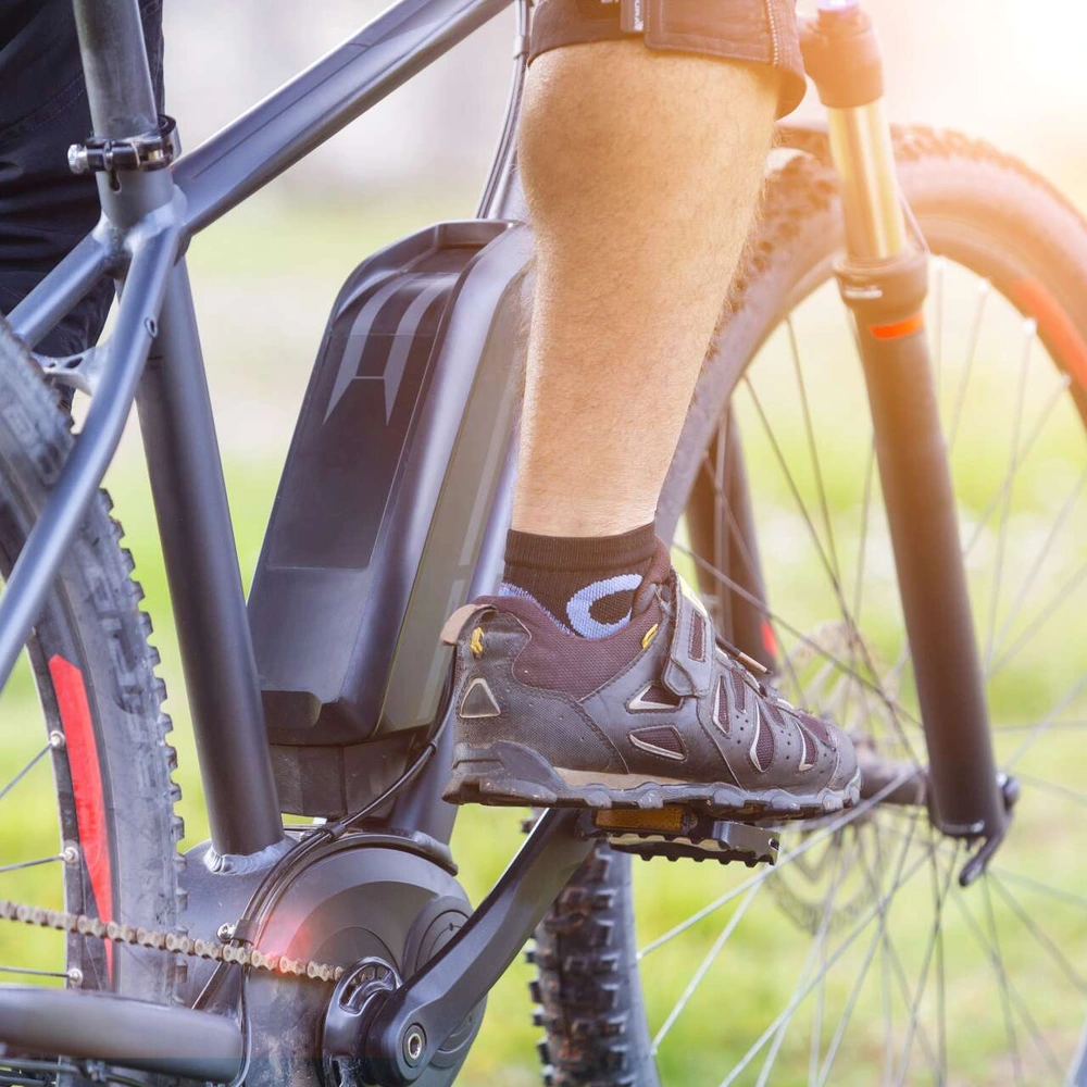 Tipps für langanhaltenden Spaß mit dem E-Bike-Akku Radfahrer mit Fuß auf der Pedale auf mit einem Elektrofahrrad