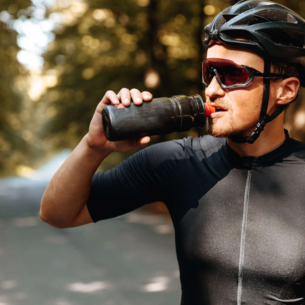Regelmäßige Reinigungen helfen gegen Keime und Schmutz Radfahrer mit Sonnenbrille trinkt aus Trinkflasche