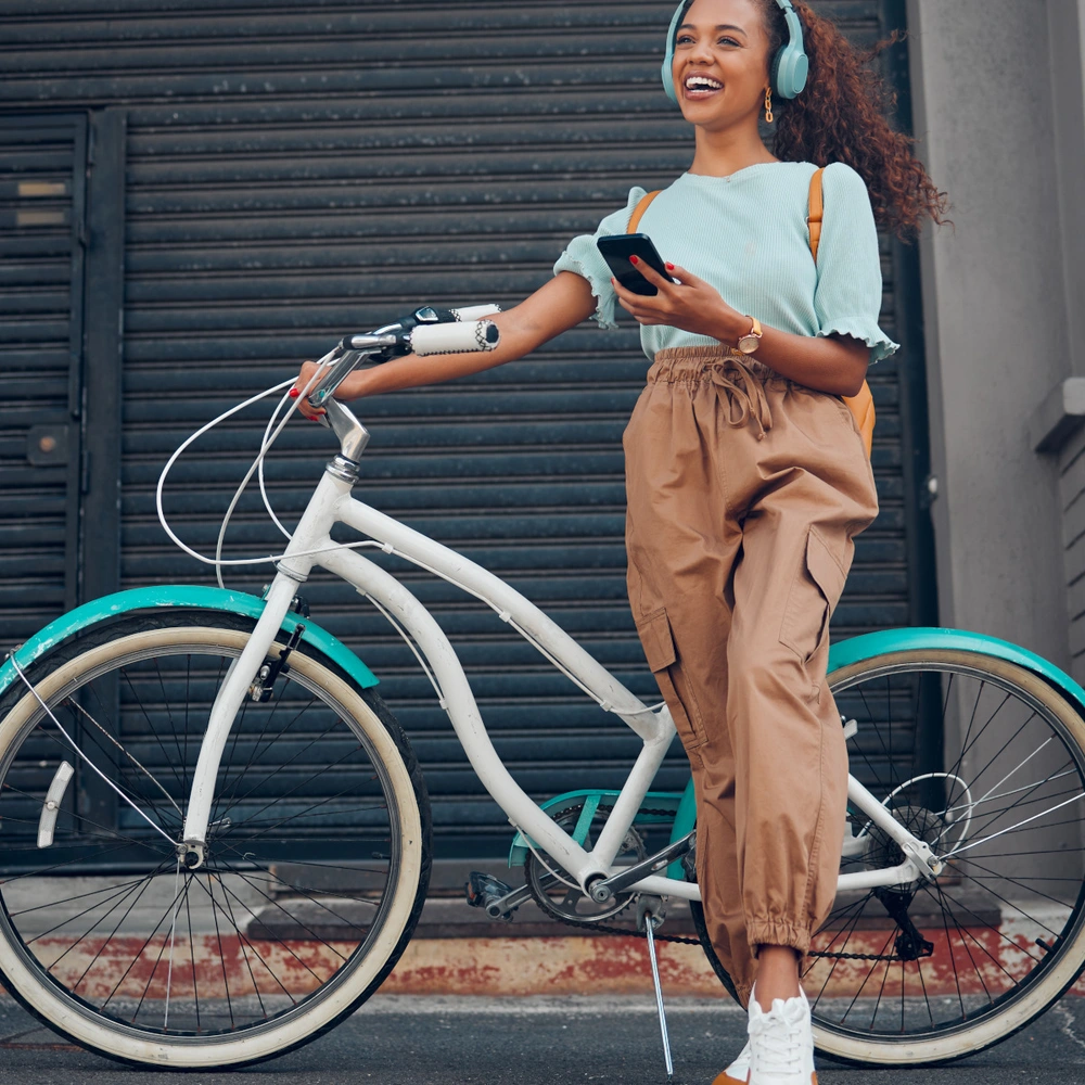 Das sind die Urban Bike Testsieger Frau steht vor ihrem Urban-Fahrrad in der Stadt.