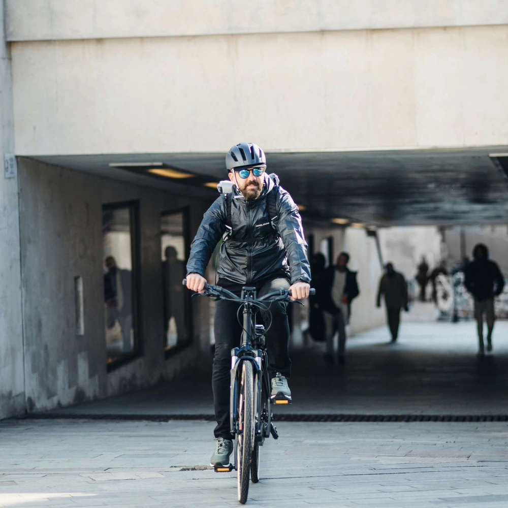 Das Urtopia Chord X: E-Bike mit Sprachsteuerung. Mann mit Helm fährt mit E-Bike durch Stadt.