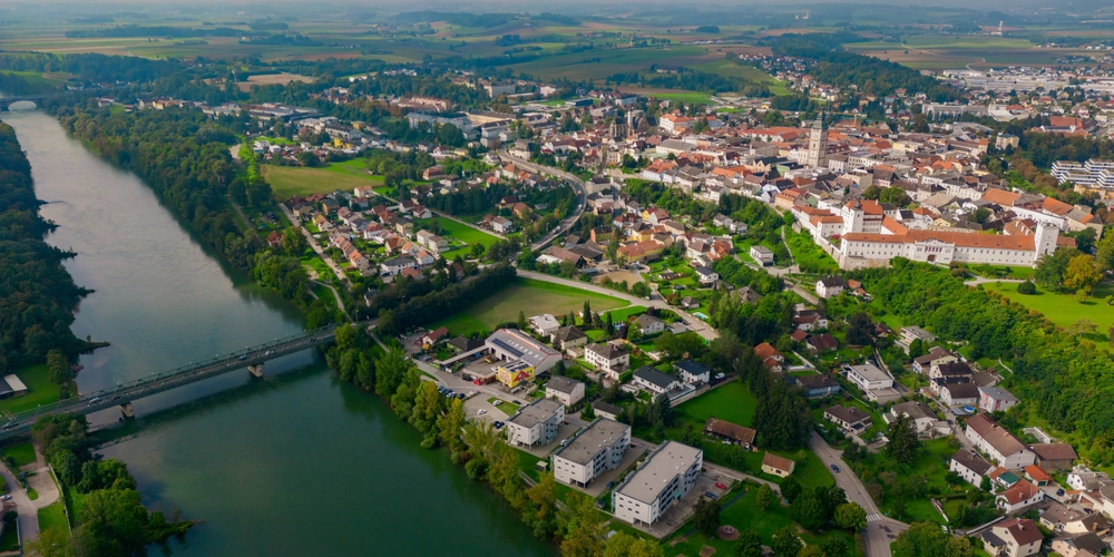 Luftaufnahme einer von Enns an der Donau mit Brücke und grünen Landschaften im Hintergrund