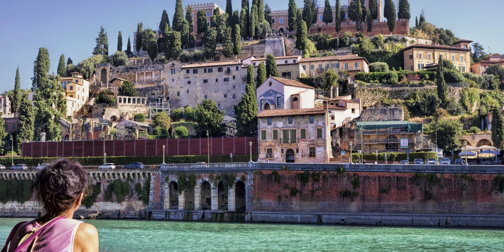 Etsch, die durch Verona fließt Frau steht an der Etsch, die durch Verona fließt und blickt auf das Stadtpanorama