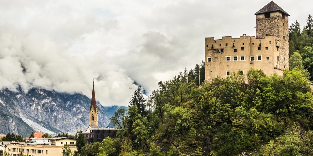 Blick auf eine das Schloss Landseck auf einem Hügel bei Wolken