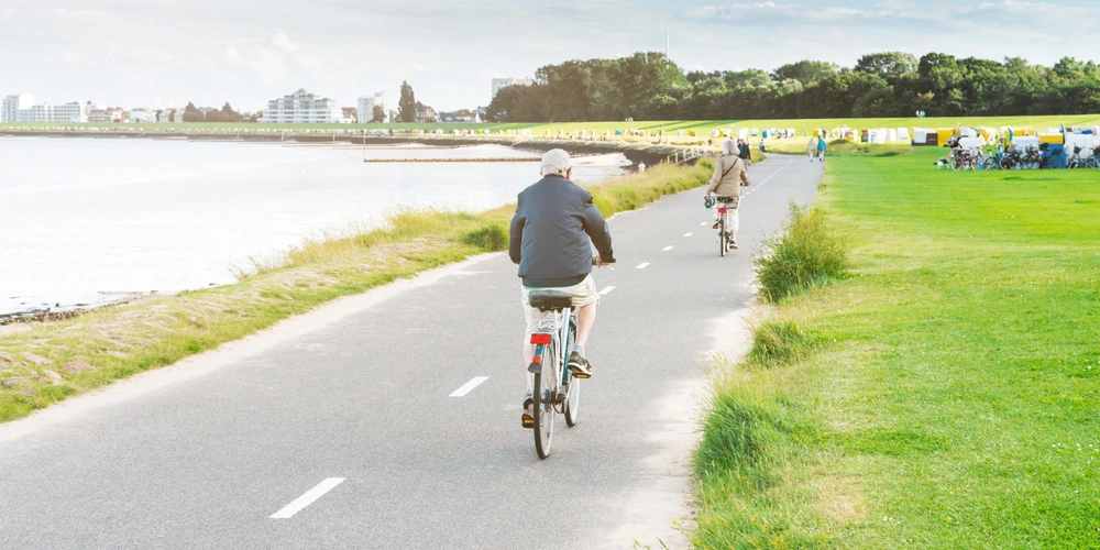 Radweg in Cuxhaven Menschen fahren mit dem Fahrrad am Ufer in Cuxhaven