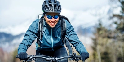 Frontale Ansicht einer lächelnden Fahrradfahrerin in Winterkleidung