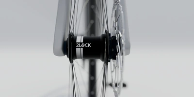 2Lock Schloss als Wegfahrsperre fürs Fahrrad Nahaufnahme eines Fahrradnabe mit Speichen auf hellgrauem Hintergrund.