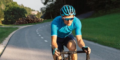 Man fährt auf einem Rennrad eine Straße hoch.