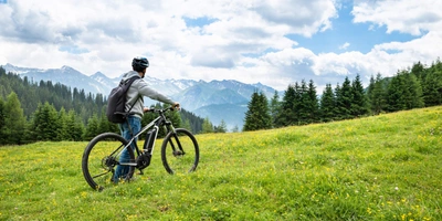 Ein Mann steht mit seinem E-Bike auf einem Berg