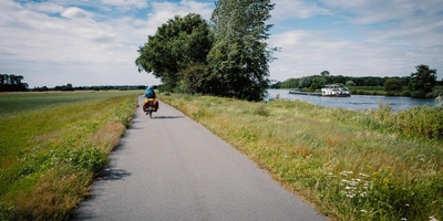 Eine Frau auf einer Radtour an der Ems