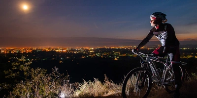 Ein Fahrradfahrer beobachtet den Mond im Dunkeln