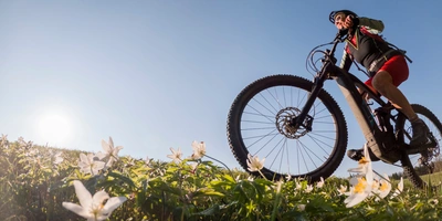 Frau fährt über eine Wiese mit einem E-Bike