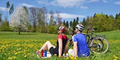 Zwei Personen sitzen neben ihren Rädern in der Sonne